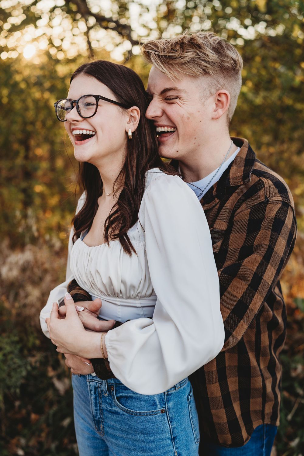 Candid laughter shared between a couple during an autumn outdoor session.