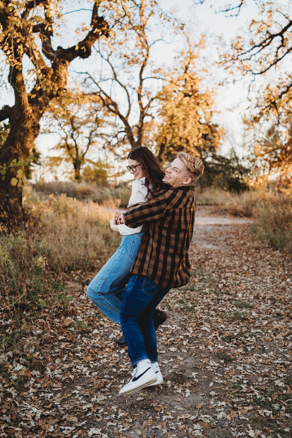 A playful dance move captured during an autumn outdoor photoshoot.