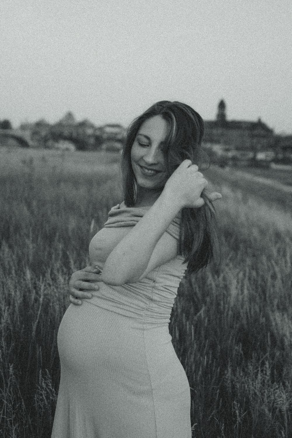 Portrait Fotoshooting im Vintage Stil - Frau mit Babybauch streicht sich durch Haare - Dresden Canalettoblick Elbwiesen Altstadt
