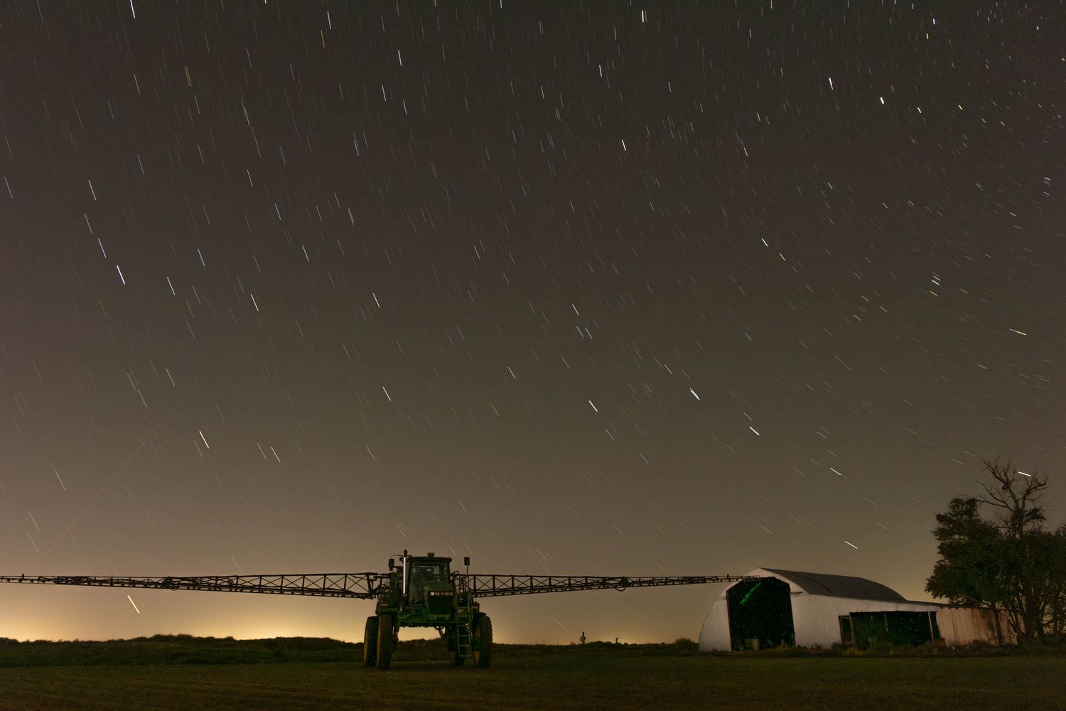 A row of buildings silhouetted against a starlit night sky with the Milky Way visible in the background.
