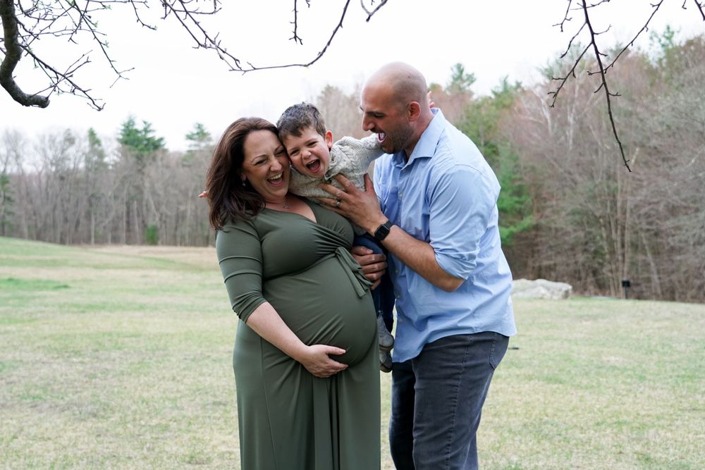 Family shares joyful moment together in outdoor field setting.
