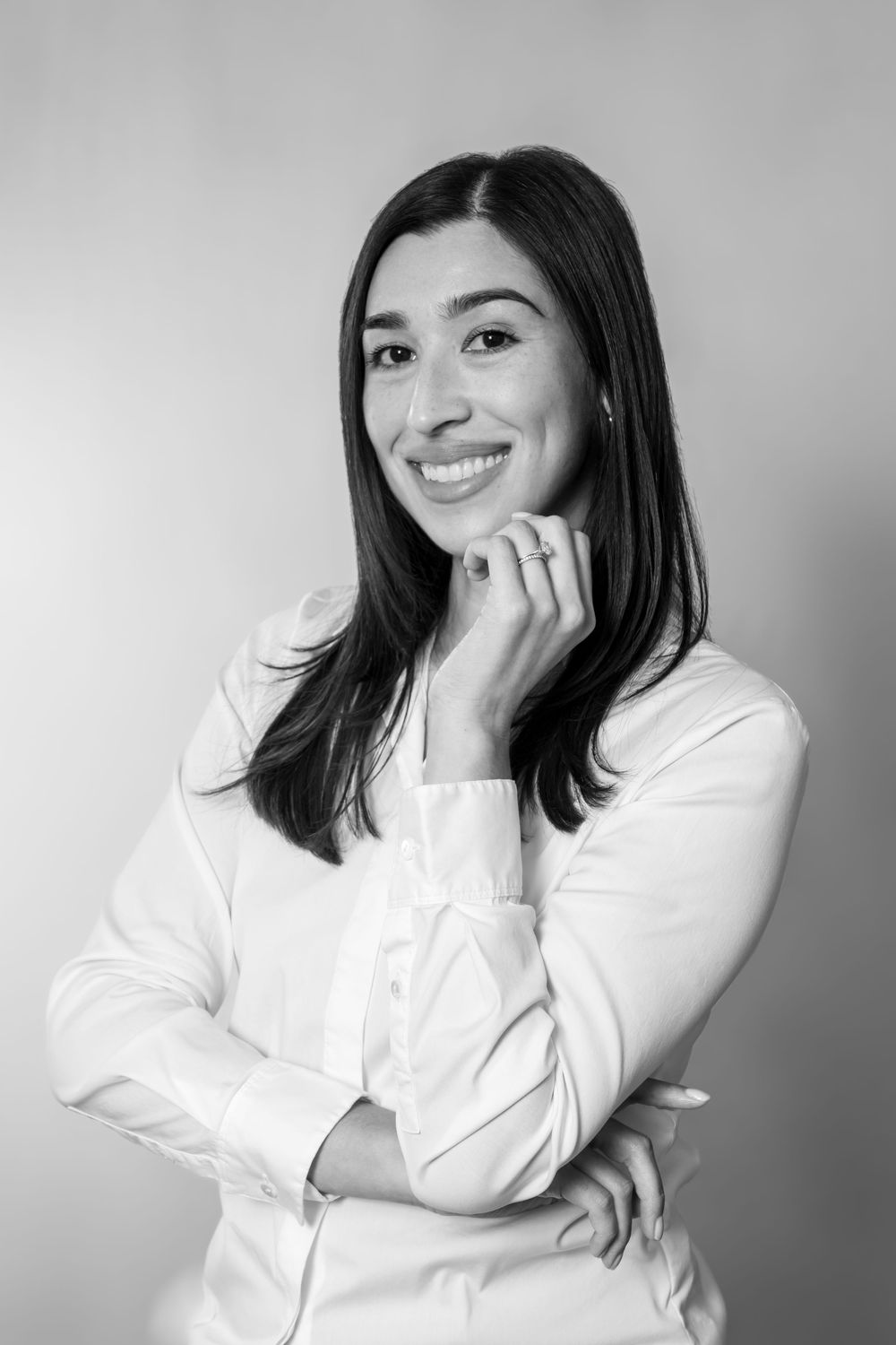 A series of black and white portraits showing a person in a white top expressing joyful emotions against a simple backdrop.