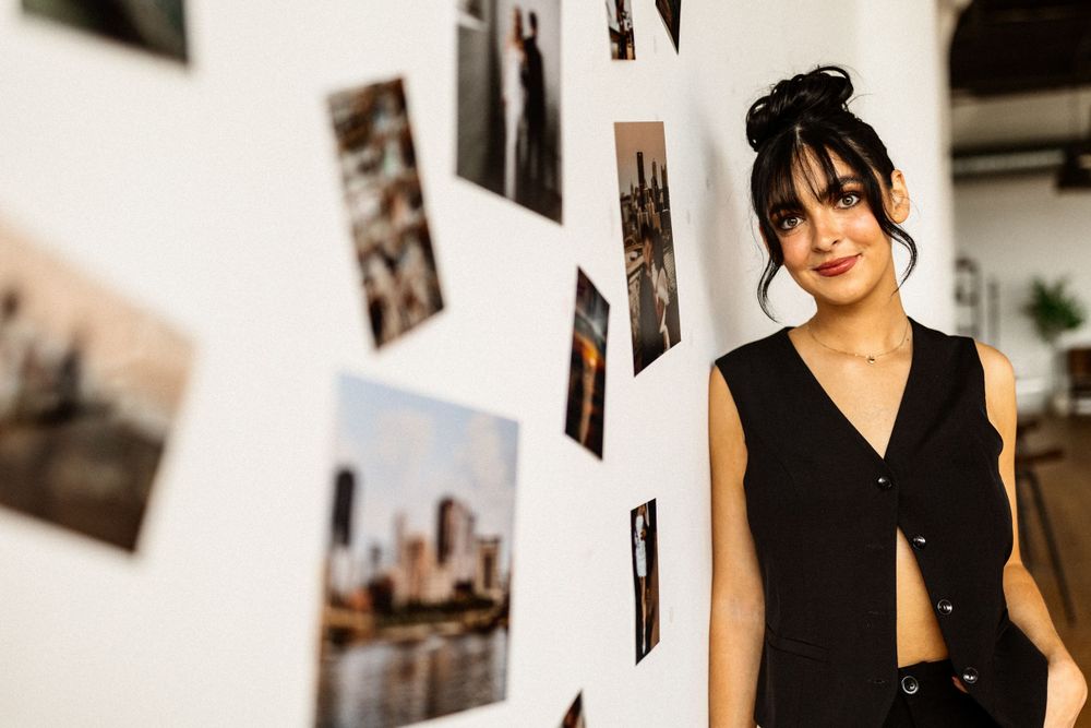 Casual portrait near a wall decorated with urban photography prints.