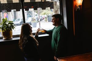 Silhouetted figures in dimly lit bar or restaurant interior. Philadelphia engagement photos.
