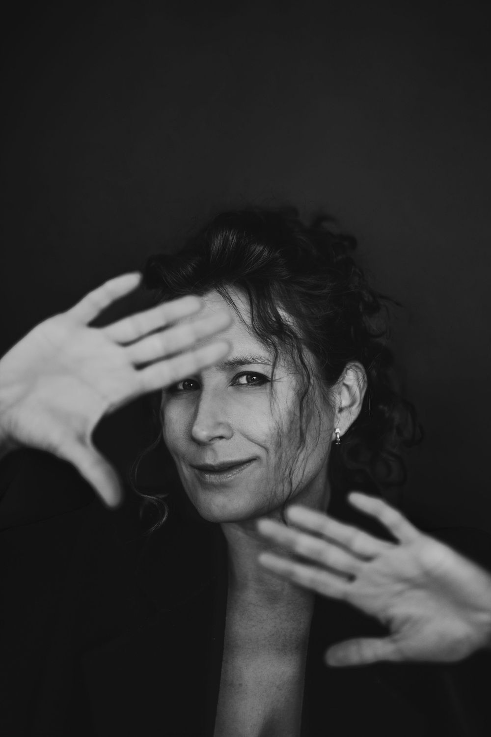 Playful portrait with hands framing face showing expressive gesture. Bellevue studio, WA
