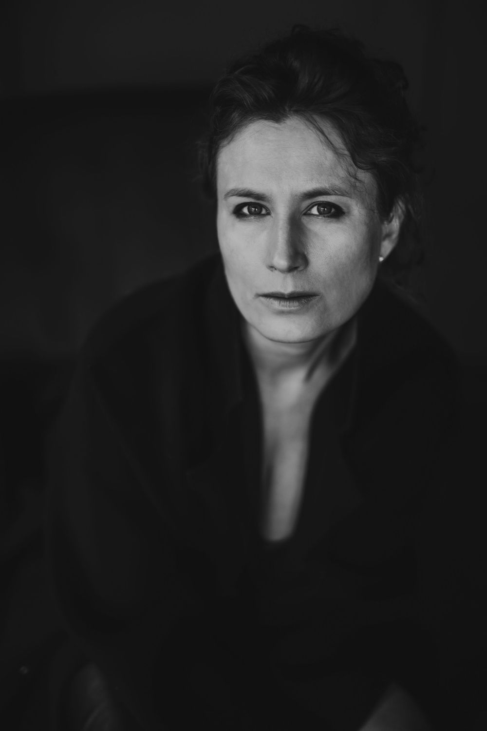 Dramatic black and white portrait with dark background and moody lighting. Bellevue studio, WA