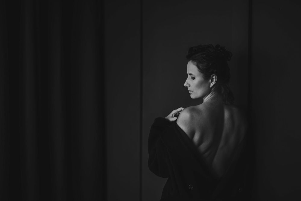 Artistic portrait showcasing bare shoulders and dramatic shadows in monochrome. Bellevue studio, WA