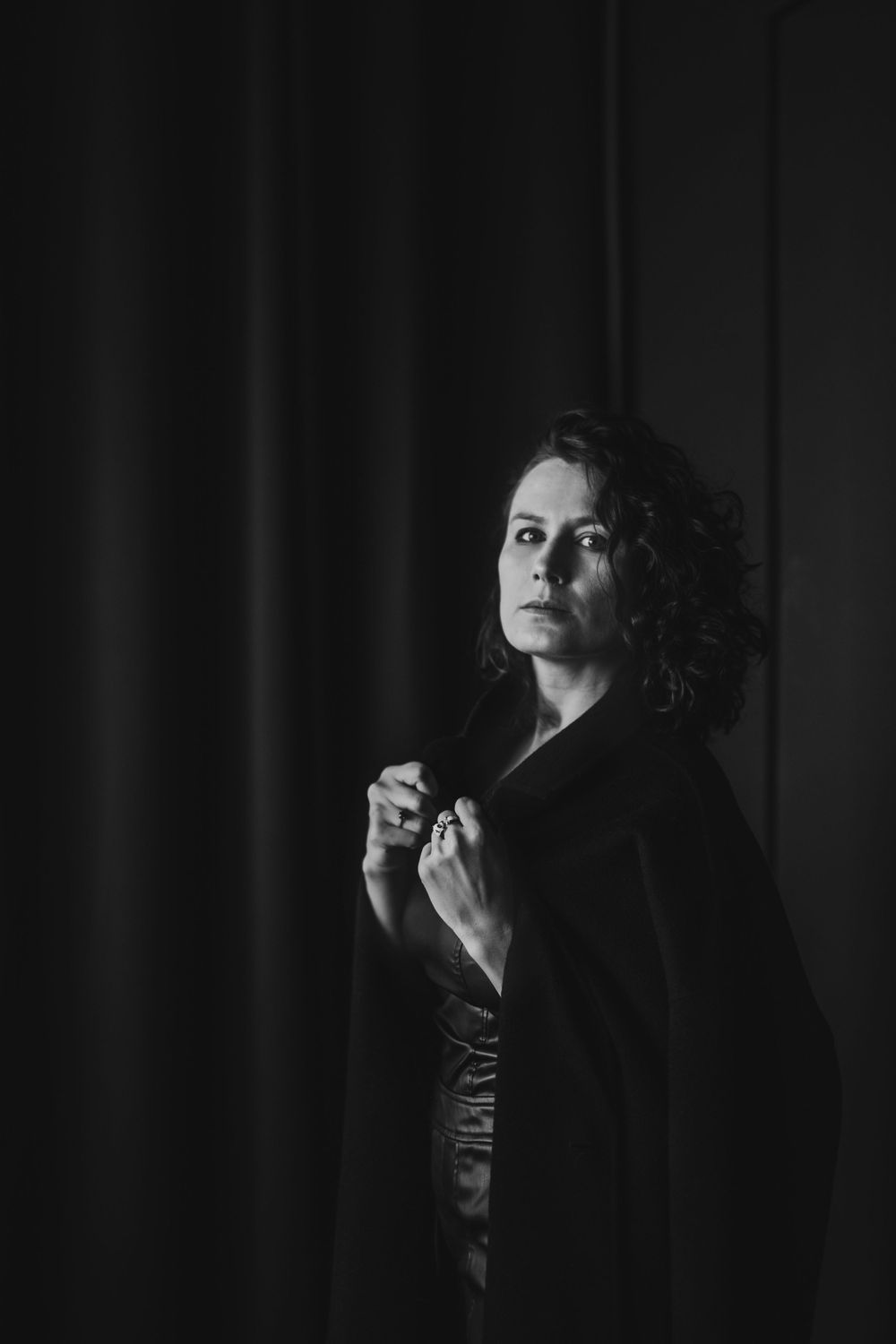 Moody black and white portrait featuring dark clothing against black backdrop. Bellevue studio, WA