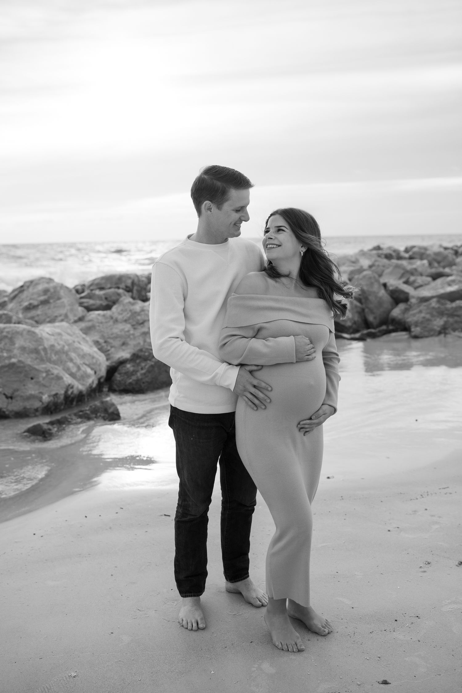A romantic maternity portrait on the beach in St Pete at sunset in black and white.