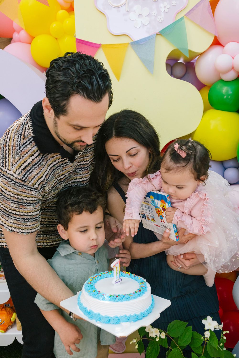 Family blowing out birthday candle, by NYC family photographer Paula Brearley NYC birthday party photographer