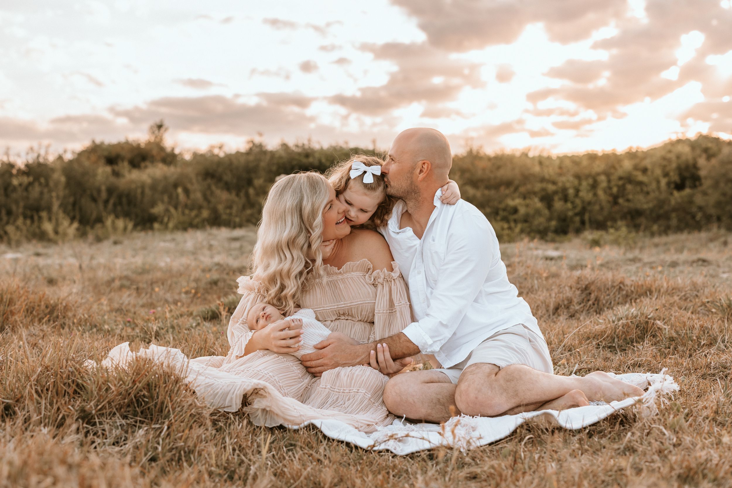 Family cuddles at sunset