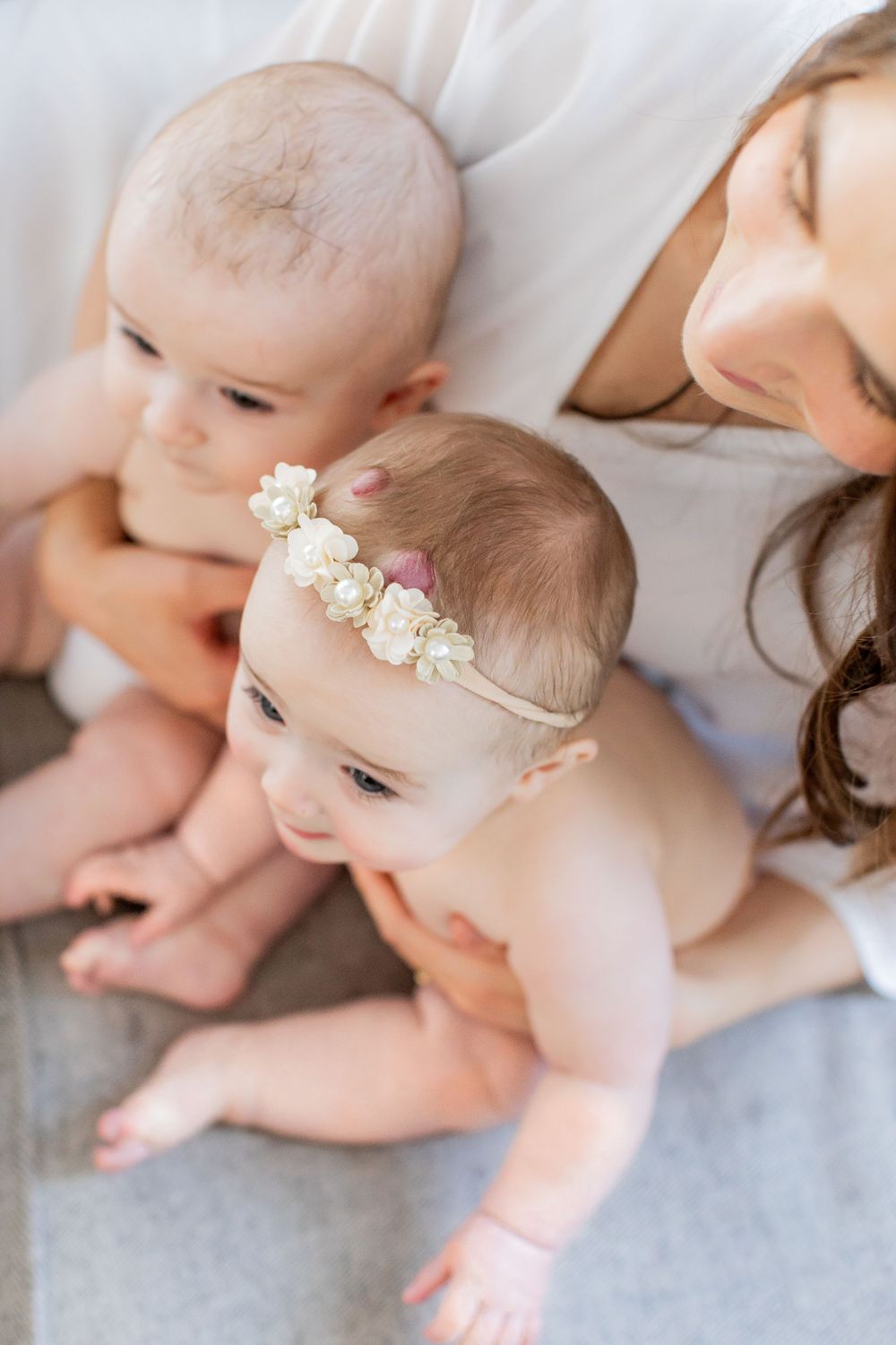 Mother holding twin babies taken in a living room during a lifestyle session in Springfield, MO.
