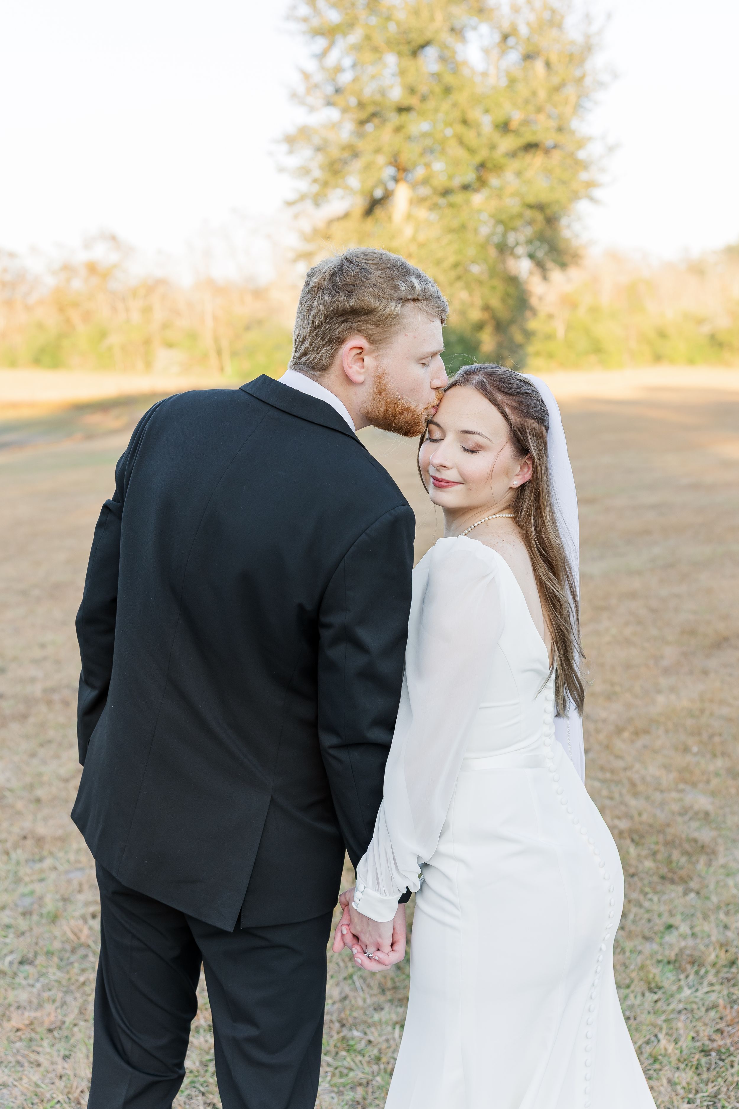 Artistic wedding photo sequence capturing a couple's intimate moments in a sunlit outdoor field.