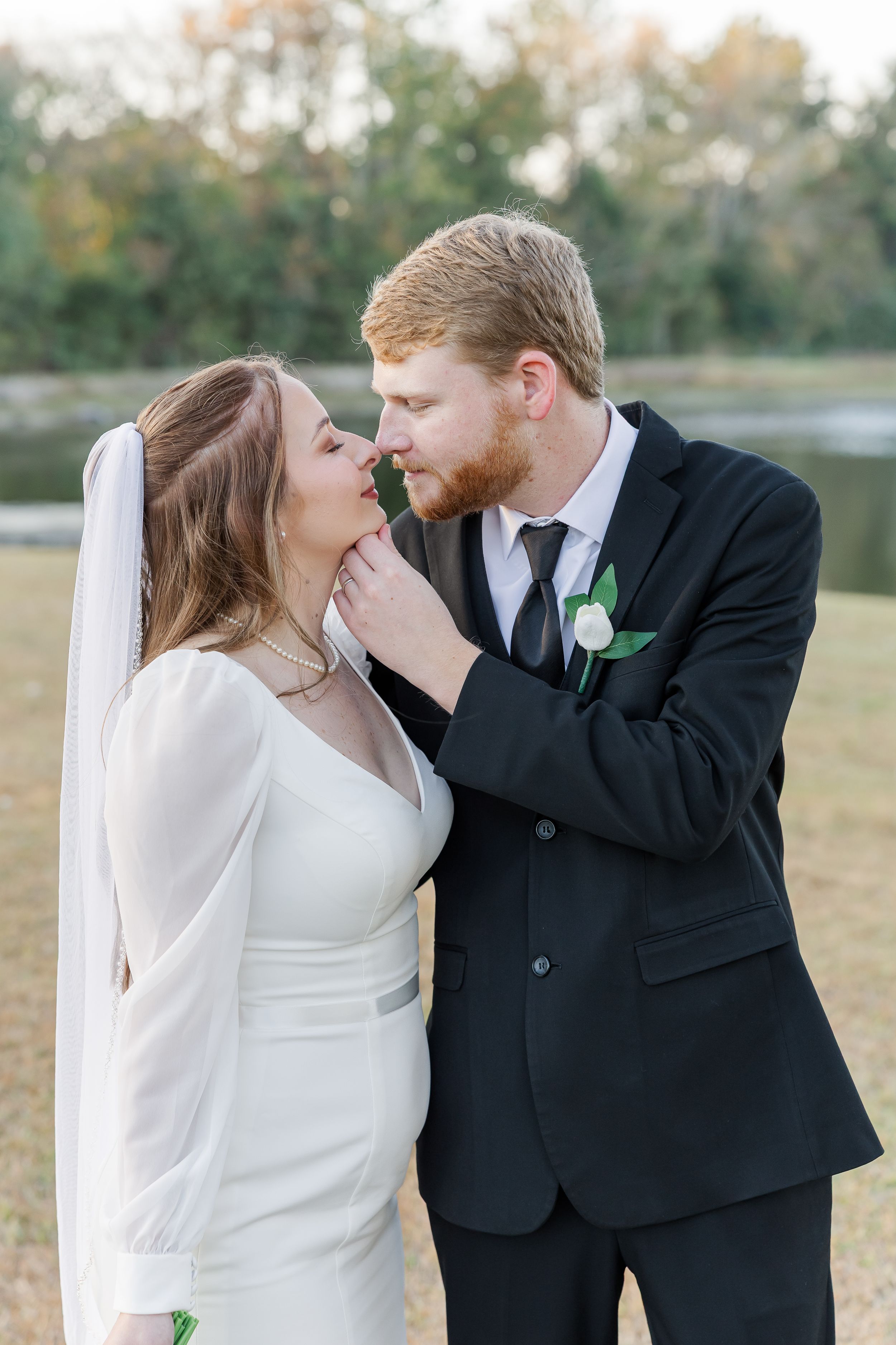 Romantic wedding couple embraces outdoors in a series of intimate poses with the bride wearing a flowing white dress and veil.