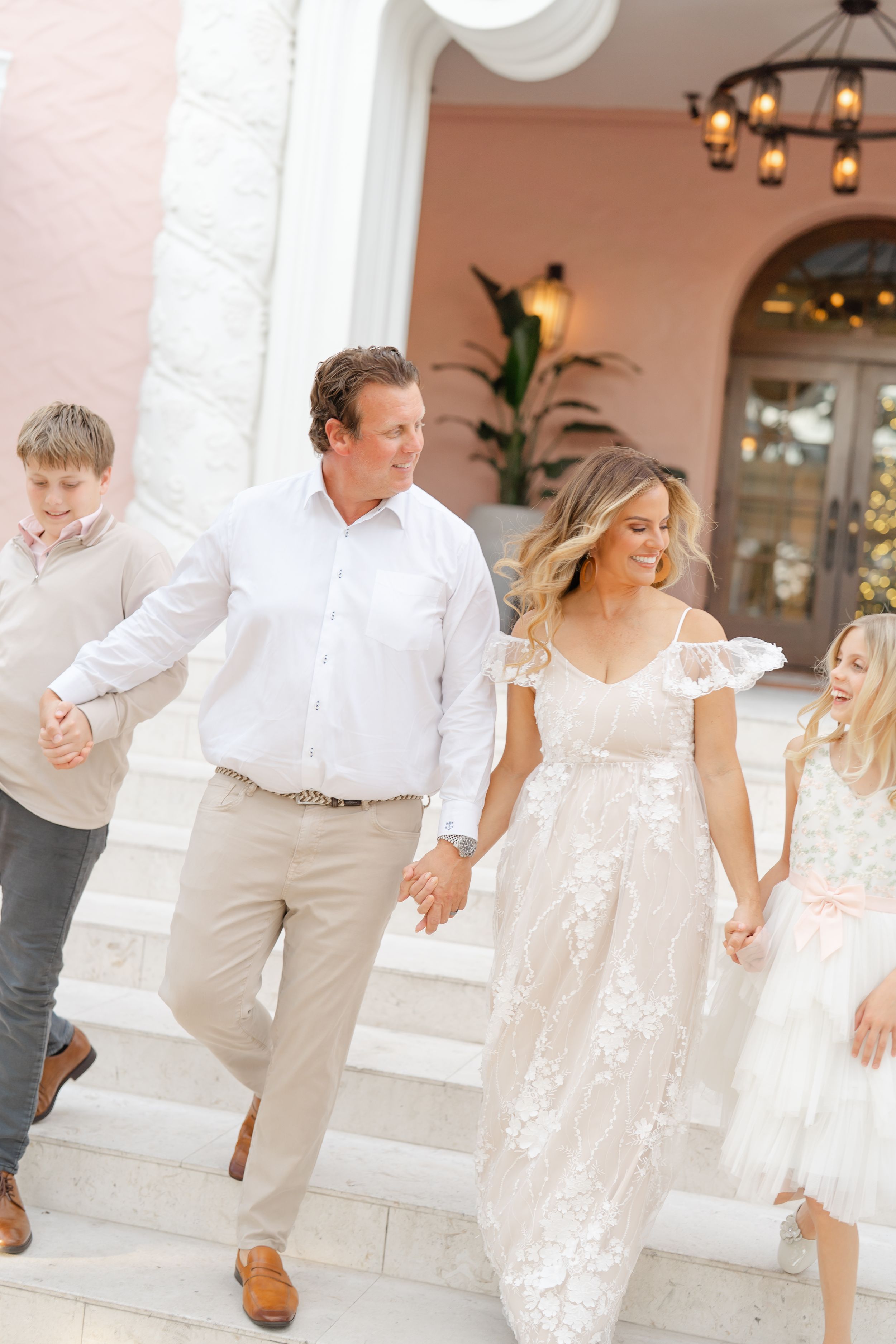 family holding hands walking down the stairs at The Vinoy in Downtown St. Pete during family photoshoot at golden hour