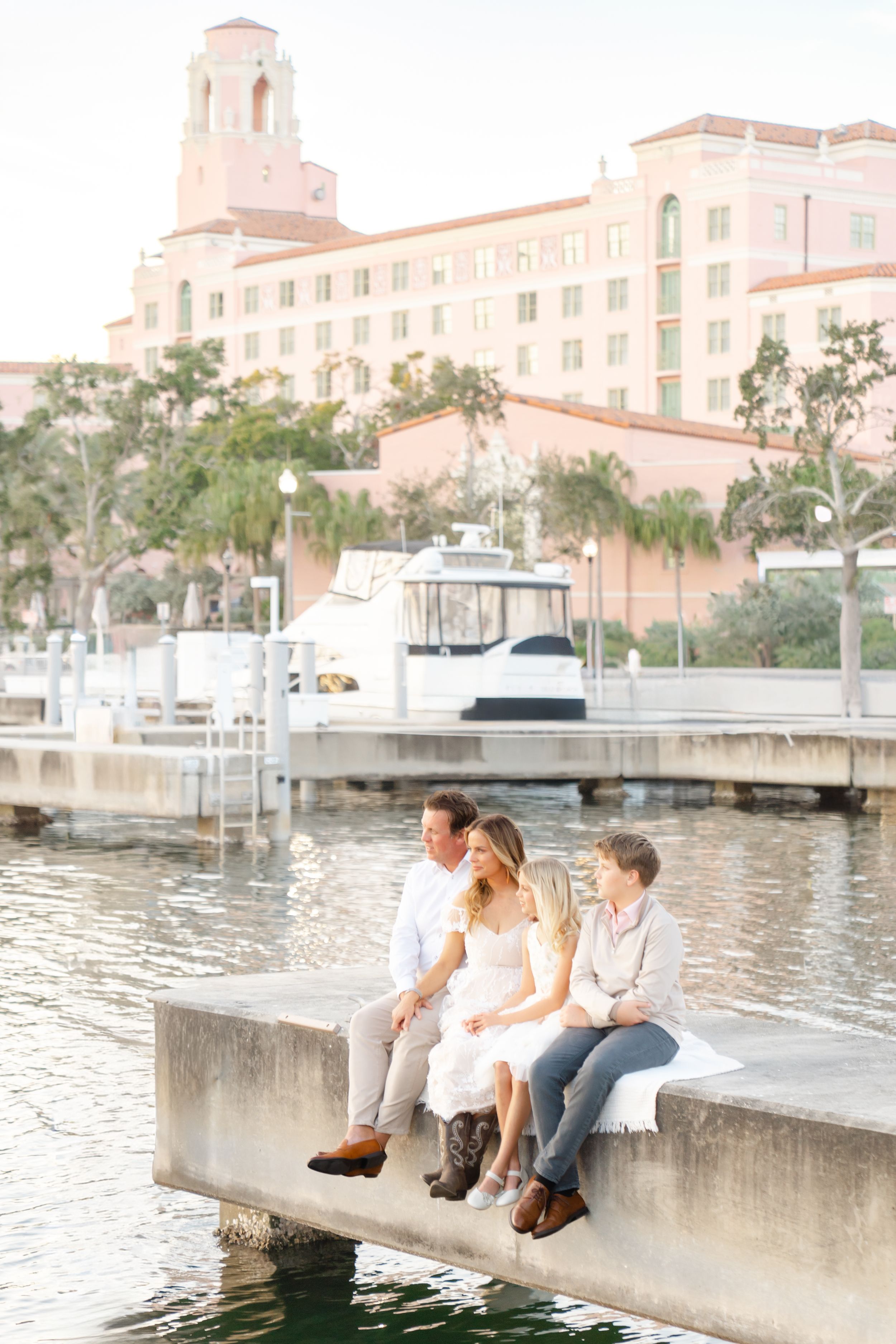 family cuddled up on the docks at The Vinoy in downtown St. Petersburg overlooking the water during their family photoshoot at golden hour