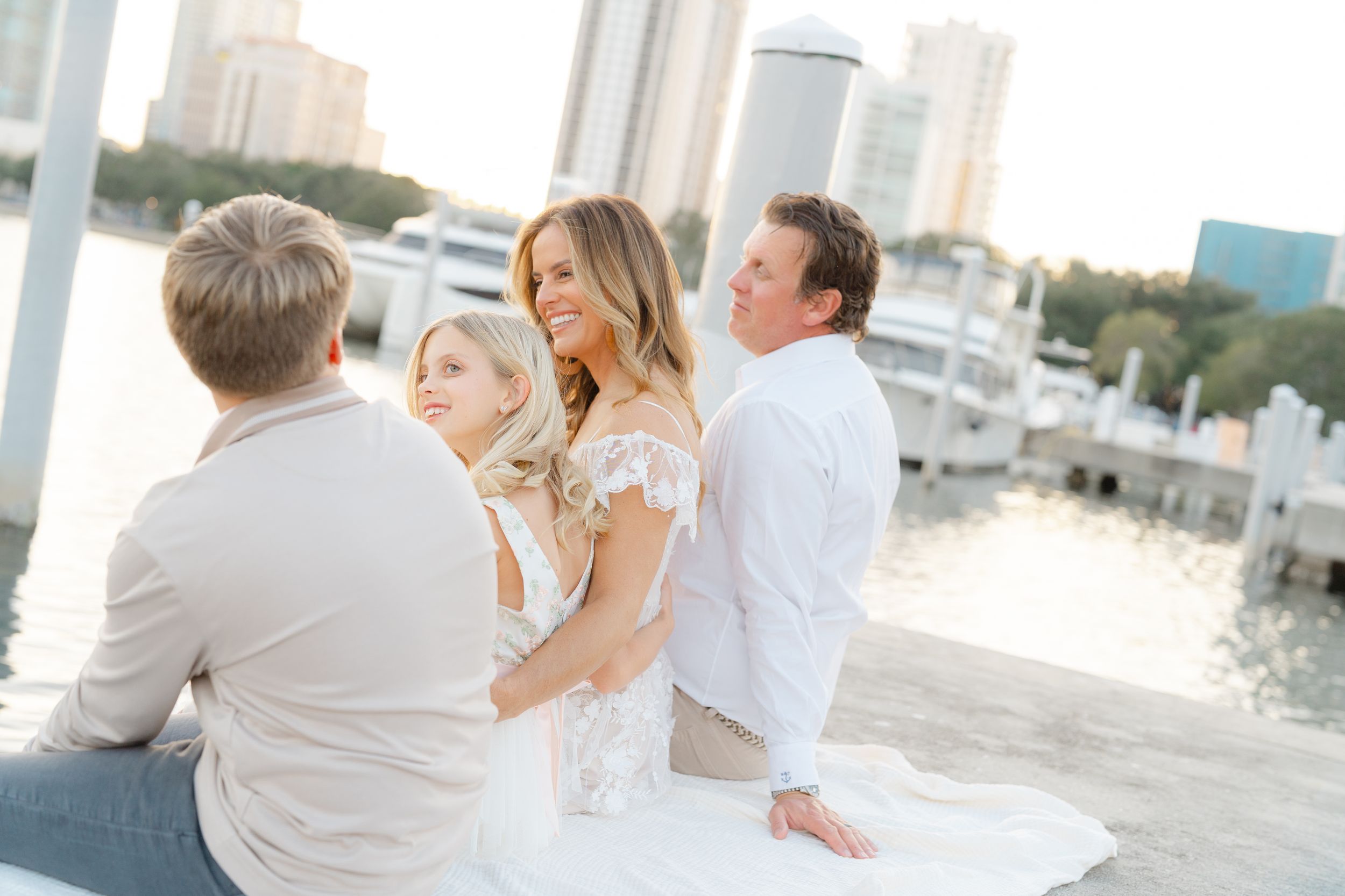 family cuddled up on the docks at The Vinoy in downtown St. Petersburg overlooking the water during their family photoshoot at golden hour