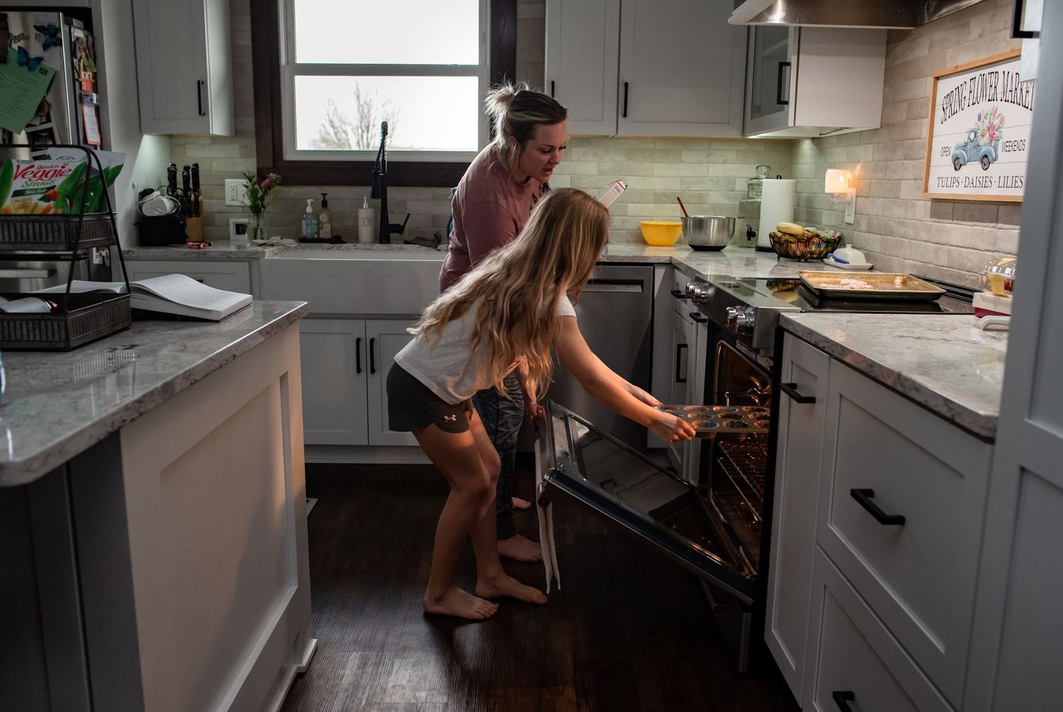 Two people preparing food together in a modern kitchen with hardwood floors during a home birth