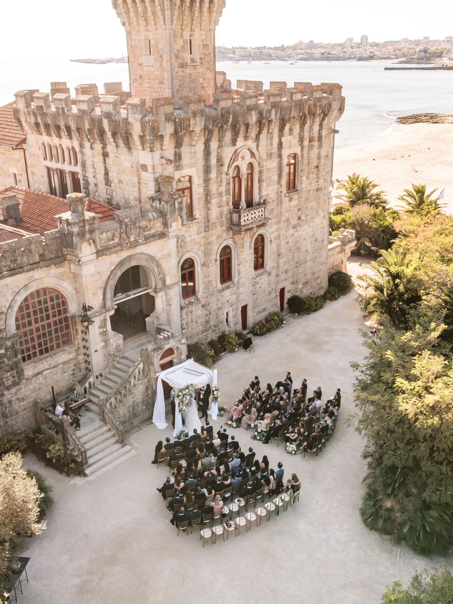 Drone view of wedding ceremony by the sea at Forte da Cruz in Cascais