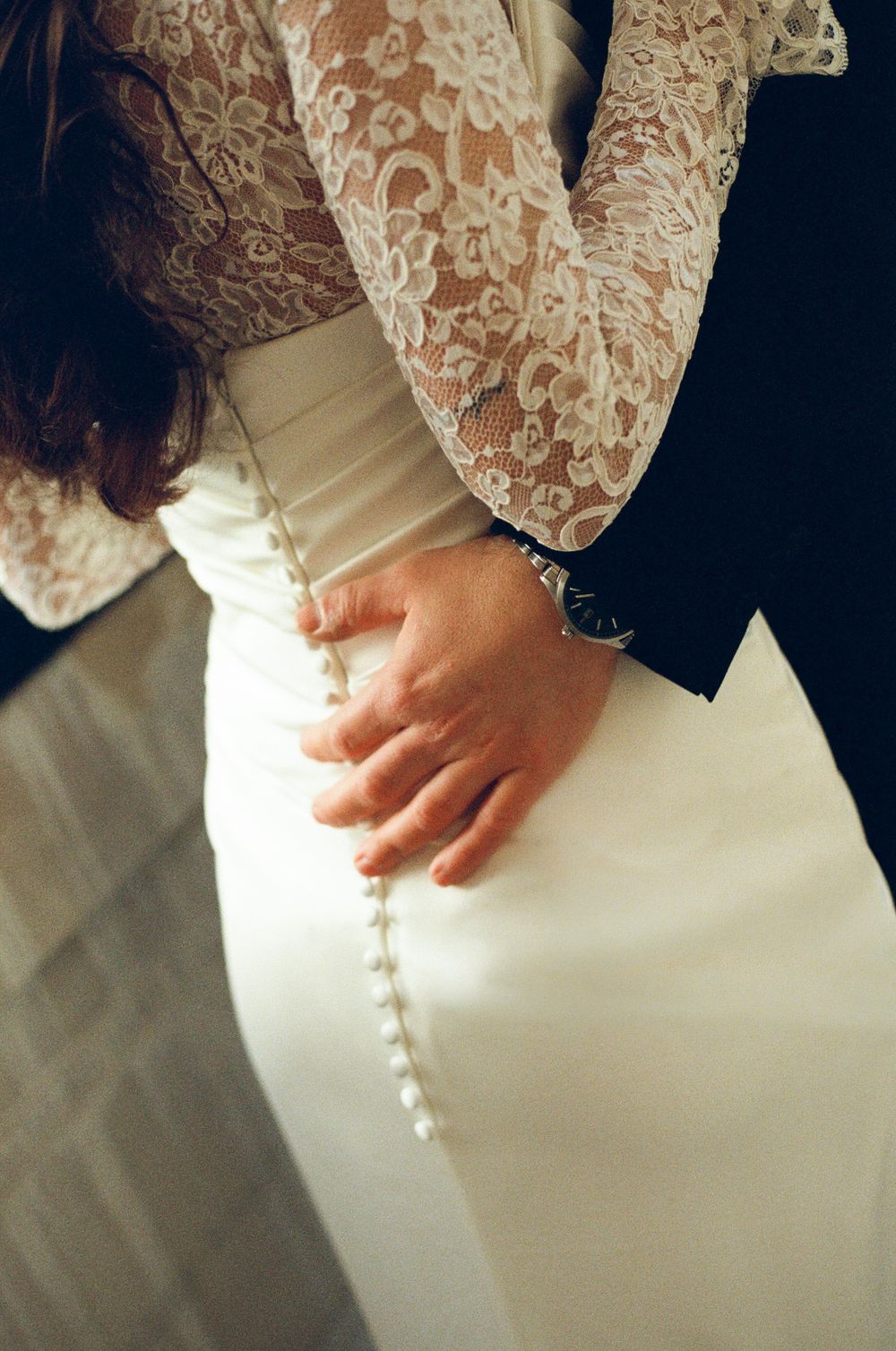 Bride and groom embracing, showcasing elegant white lace wedding dress. Paris wedding photos on film, paris bridal detail, film photography