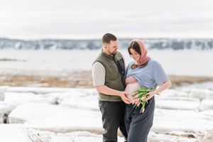 Portrait fine art d'une couple de futurs parents sur les rives enneigées du fleuve st-laurent
