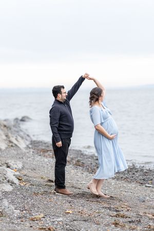 Couple dansant au bord de l'eau lors de leur séance maternité extérieur à Québec