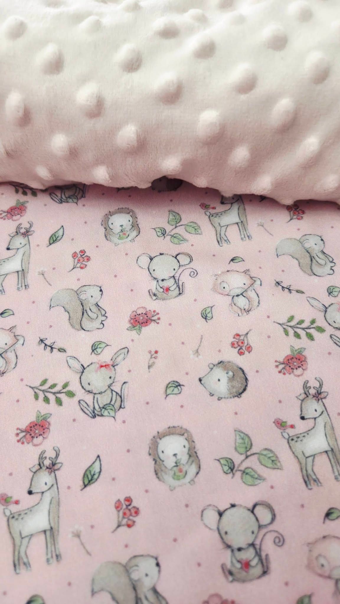 Pink minky baby blanket with woodland animals print featuring deer, hedgehogs, bunnies, and squirrels on soft fabric.