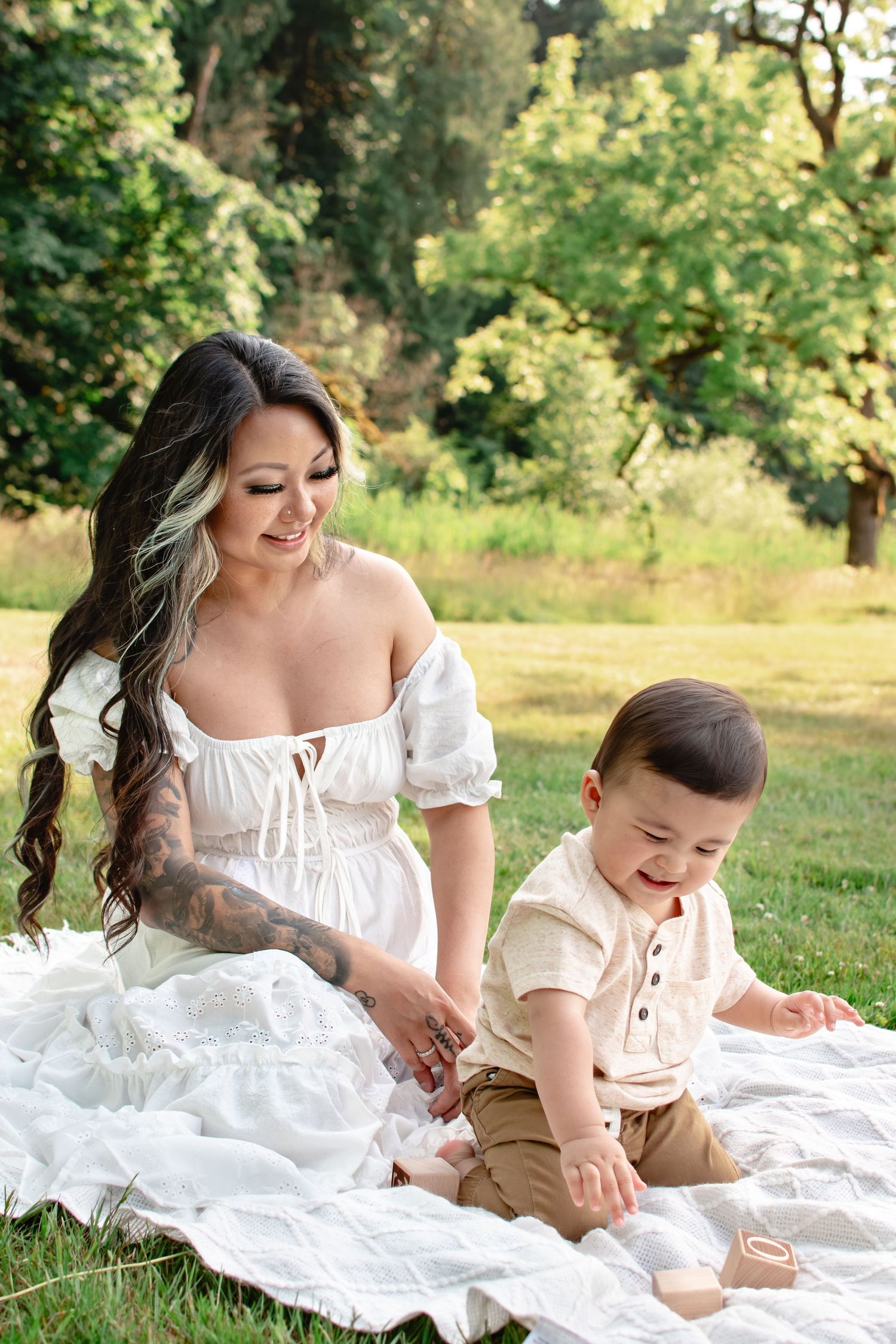 Mother and baby sitting on blanket during relaxed outdoor motherhood photo session in Seattle