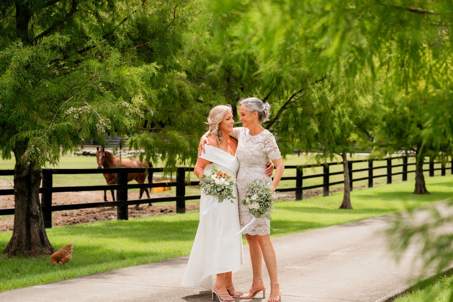 Two brides walking arm in arm down a country path. Relaxed, joyful wedding photography in Northern NSW hinterland. Tumbulgum wedding.