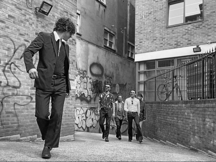 Urban alley with brick walls and walking figures in black and white.
