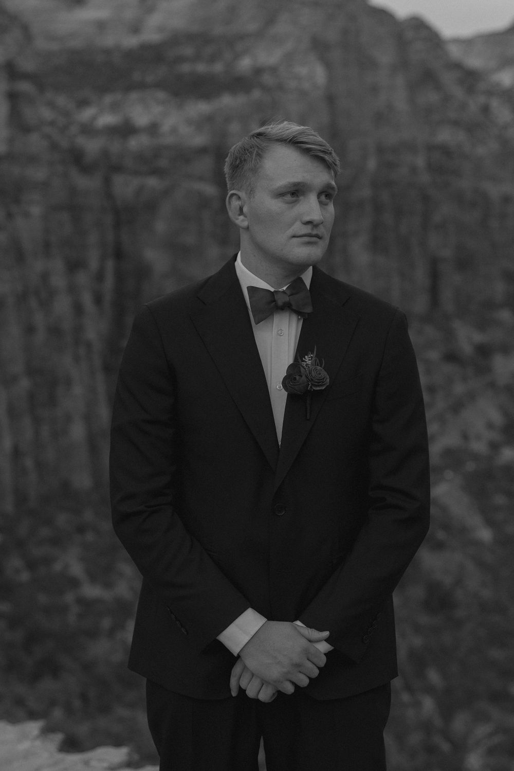 A black and white wedding portrait captured against the majestic backdrop of towering canyon walls.