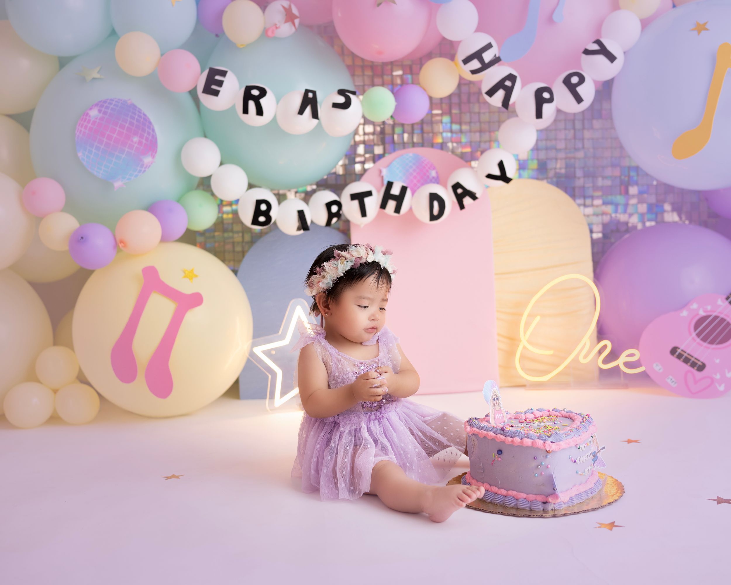 Birthday celebration with cake and pastel balloon decorations.