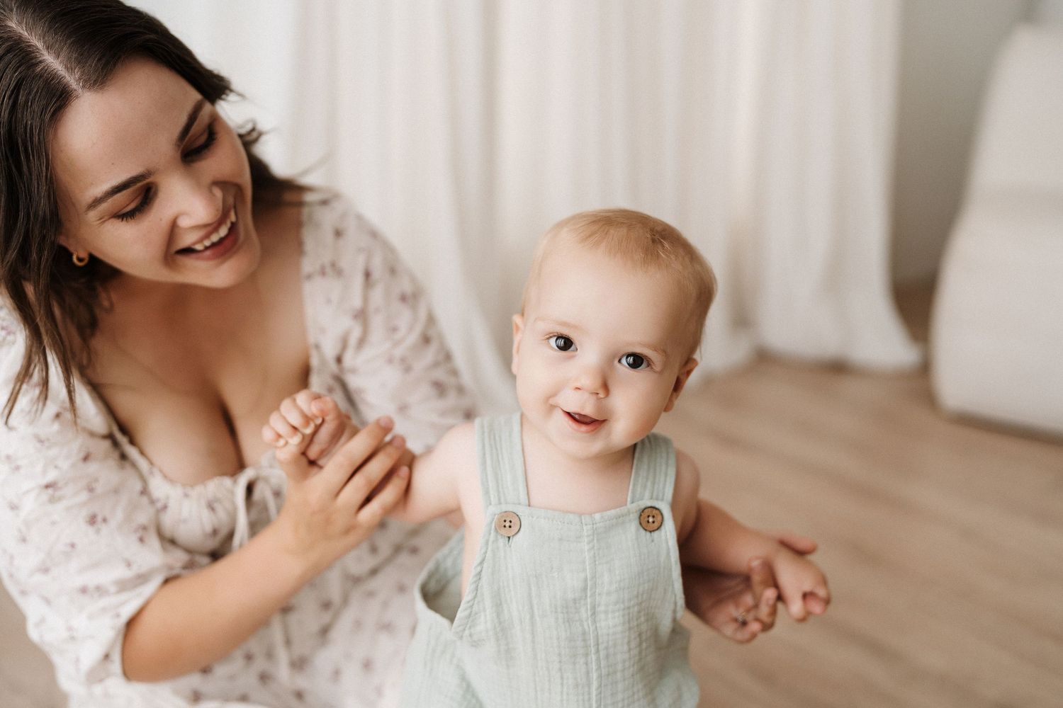 Joyful mother-child interaction captured in bright natural light studio setting.