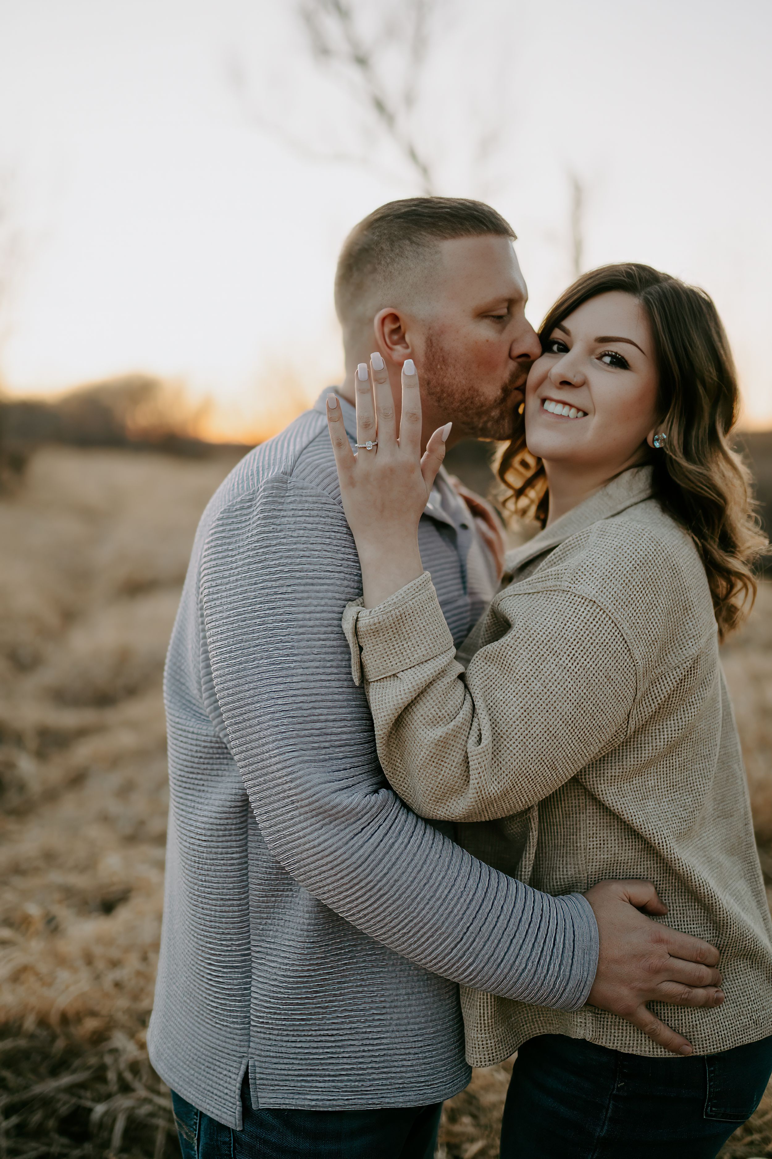 Candid engagement photography showing sweet moments between a couple at sunset.