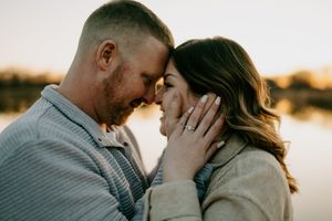 Tender moment between couple during sunset photoshoot.