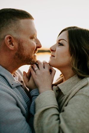 Romantic couple sharing an intimate moment at sunset by a lake.