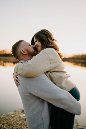 Intimate embrace captured during golden hour lakeside photo session.