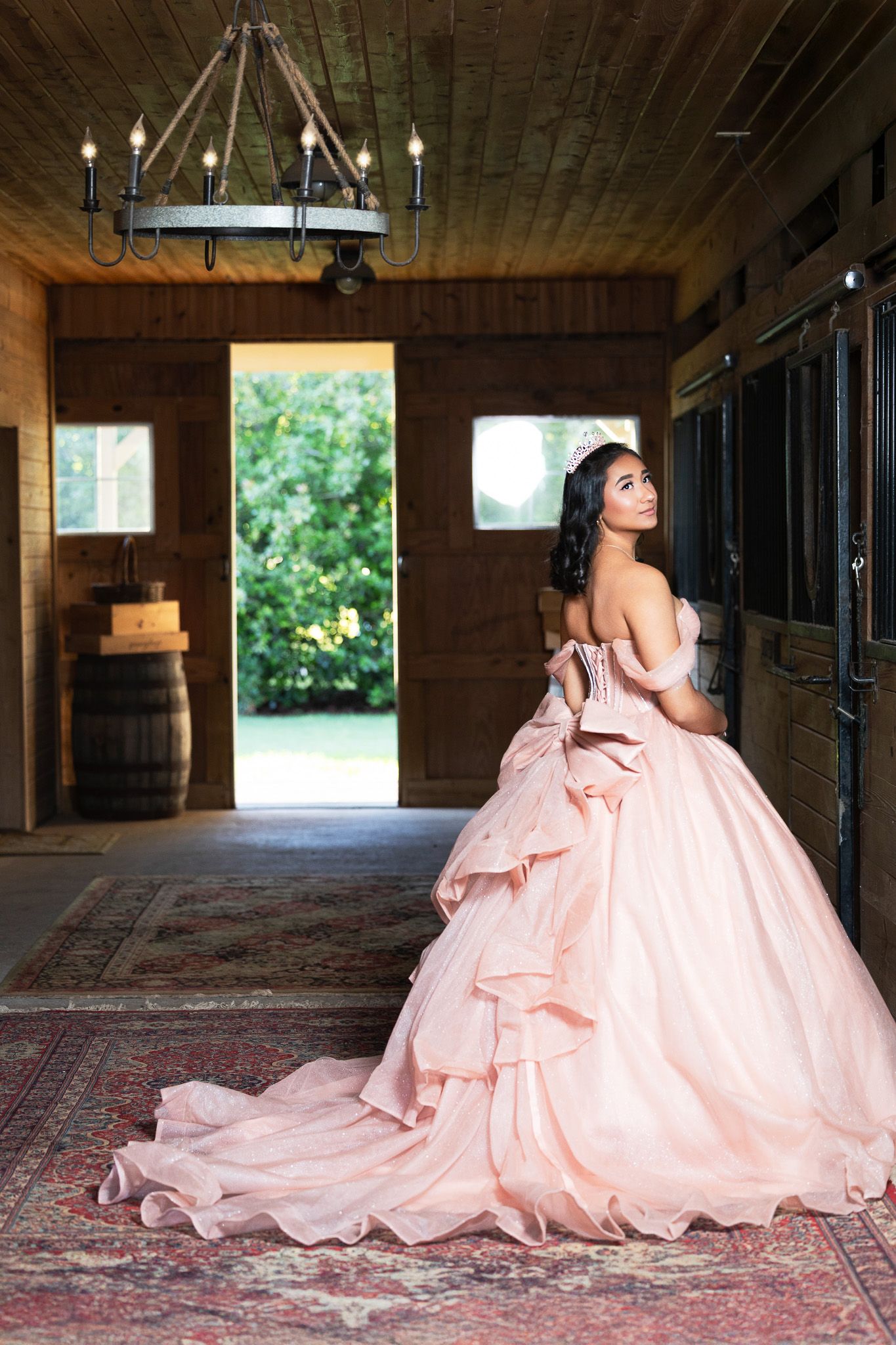 A blush pink ball gown with dramatic train photographed in rustic wooden interior.