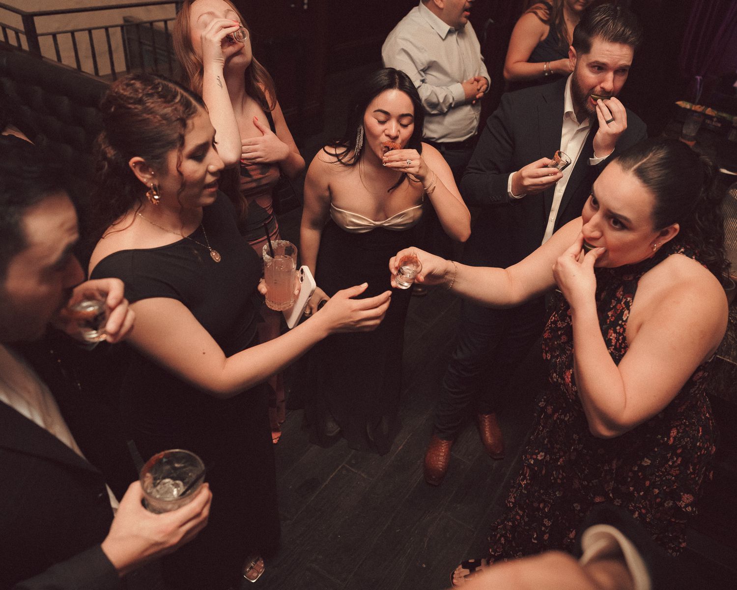 A group of people wearing black dresses share a moment with drinks and laughter at a wedding reception in Las Vegas.