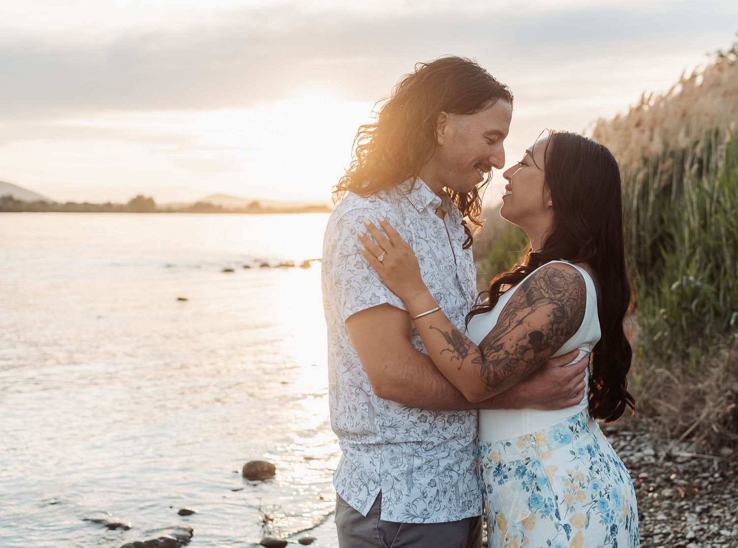 An engaged couple share an intimate moment together at sunset by the water on the Columbia River at Chiawana Park in Pasco, Washington.