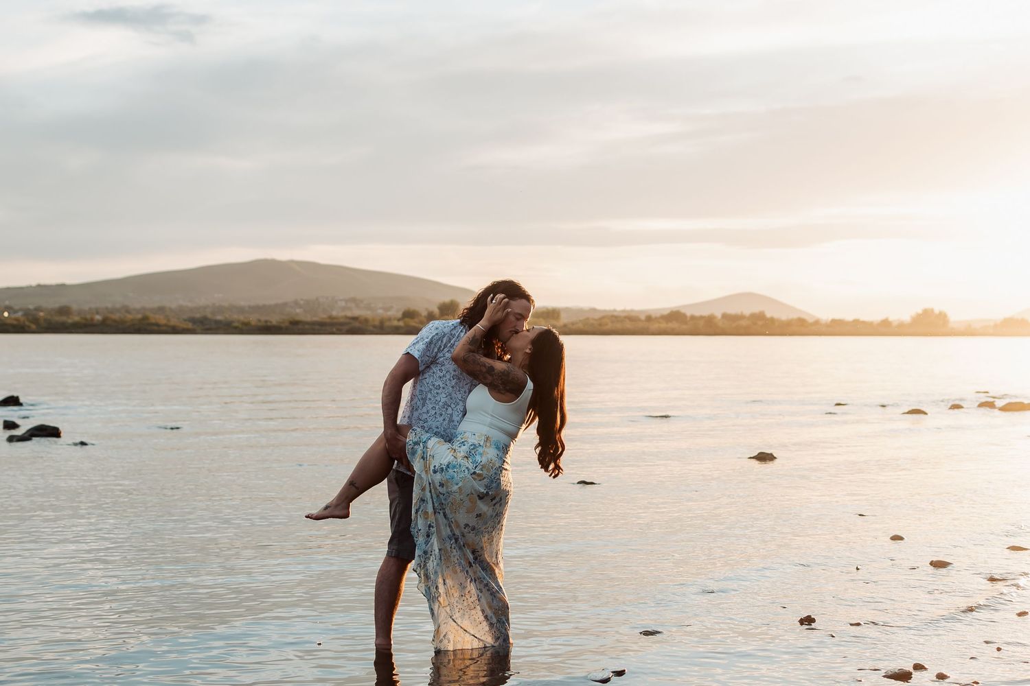 A couple enjoys a romantic embrace on the Columbia River Bank in Tri Cities, Washington.