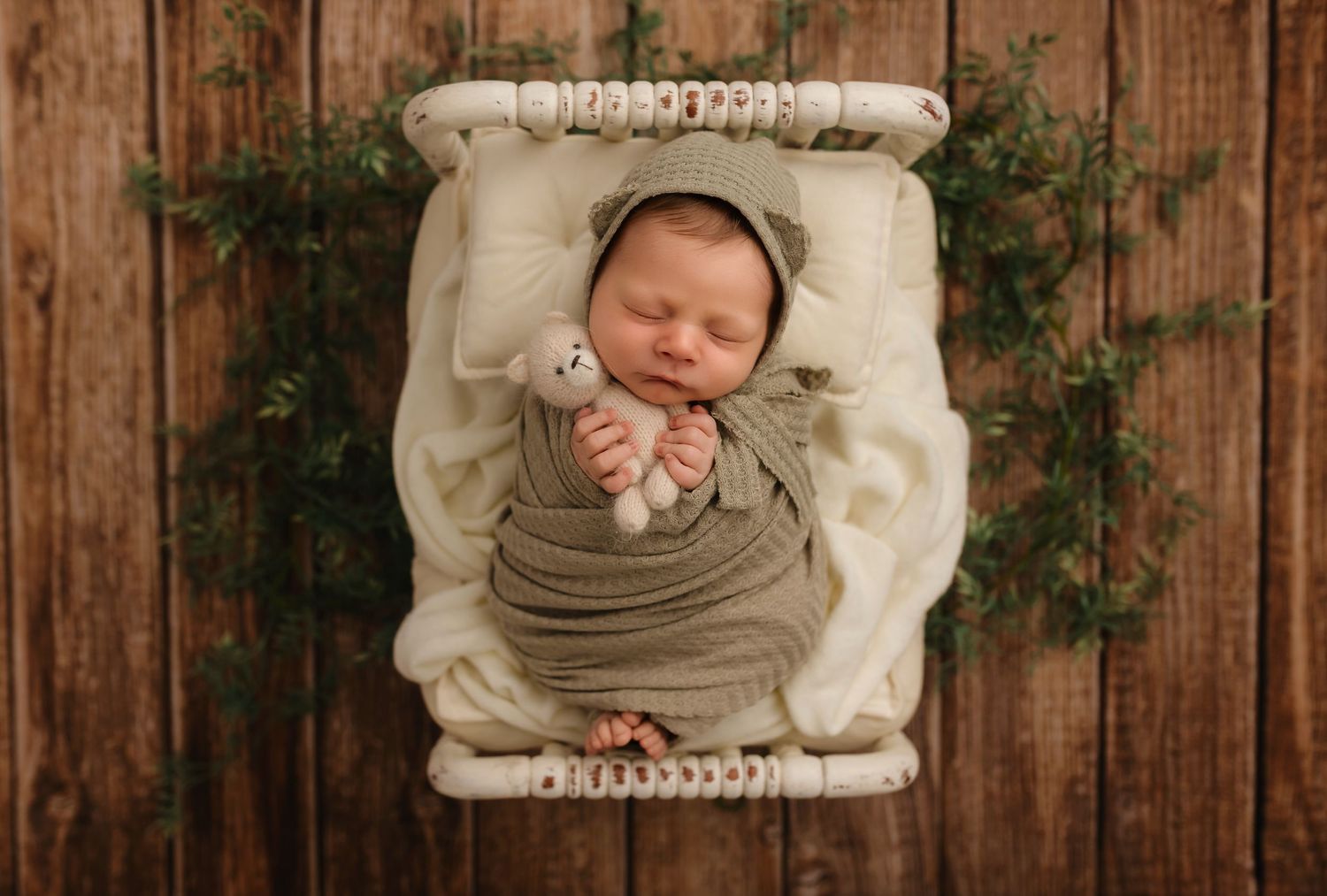 Charlottesville photographer, newborn, family, maternity; baby wrapped in muted green with bear-hat snuggles in bed with a tiny teddy bear.