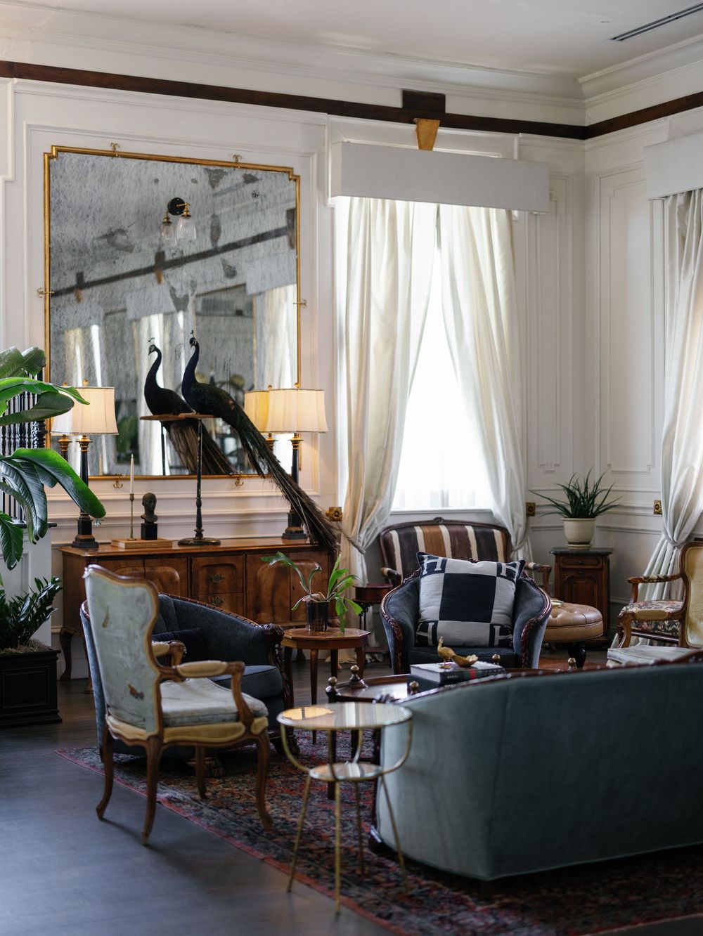 Elegant living room interior with vintage furniture, white curtains and soft natural lighting.