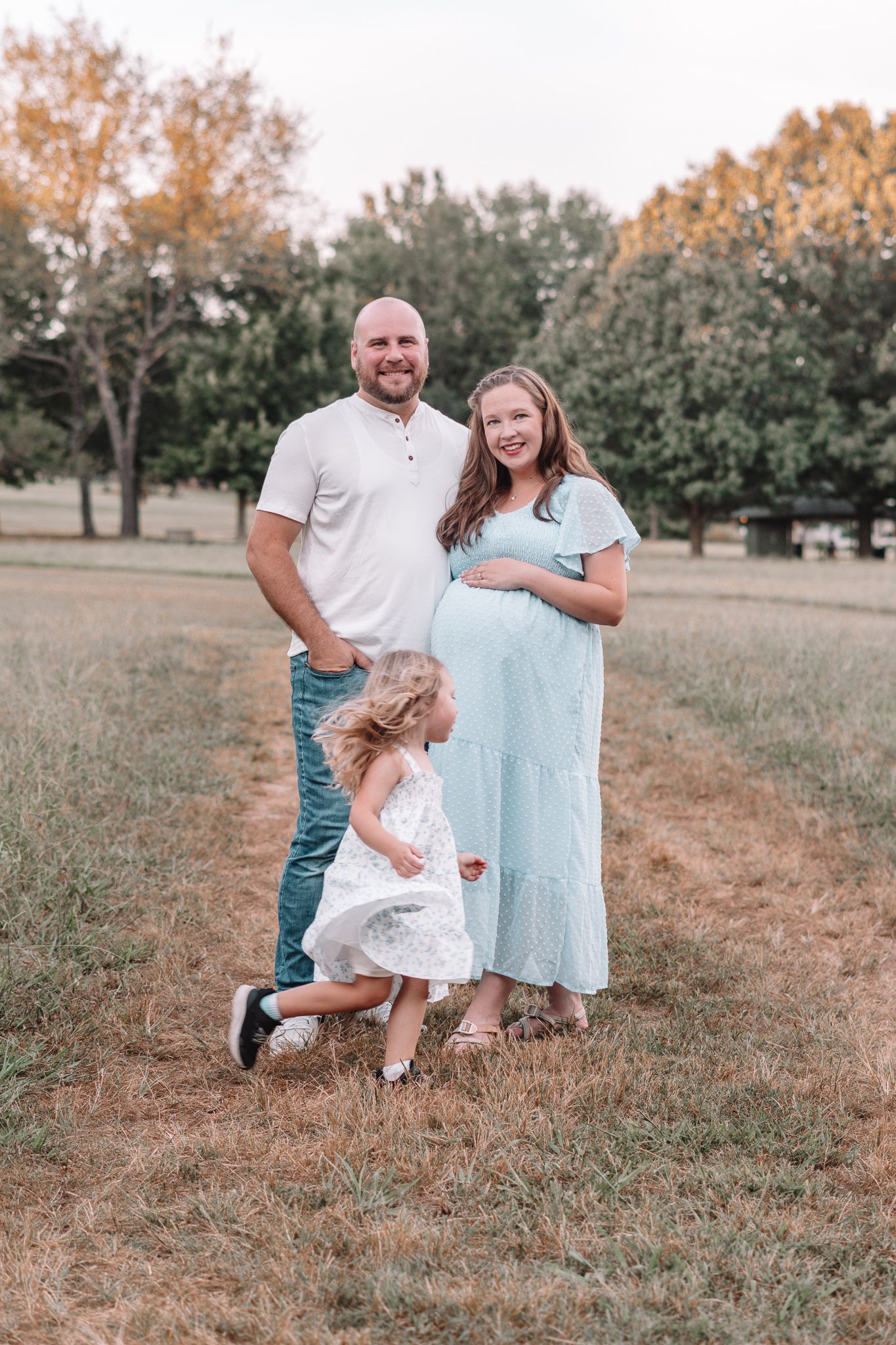 Candid family interactions photographed in a grassy field at golden hour.