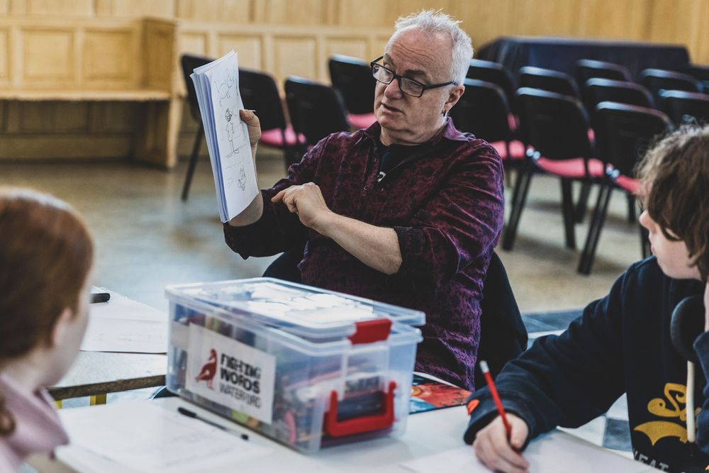 Senior citizens participate in a classroom setting with papers and materials on their desks.