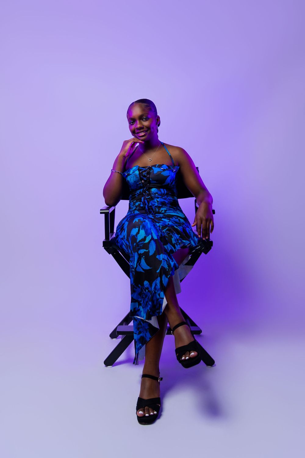A person in a blue floral dress poses against a purple background in a series of dynamic seated positions.