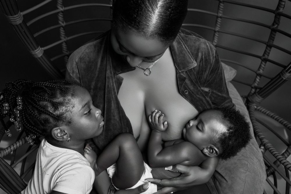 Black and white photograph captures intimate family bonding moment.