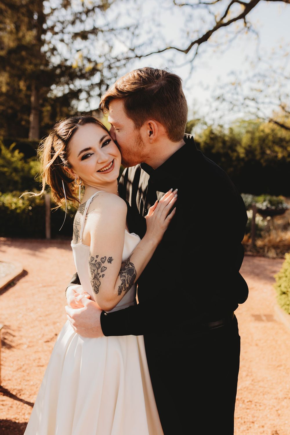 A couple shares joyful laughter during their outdoor wedding photoshoot.