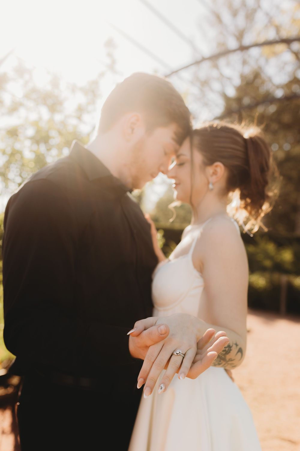Newlyweds share an intimate moment in golden hour lighting during their wedding portraits.