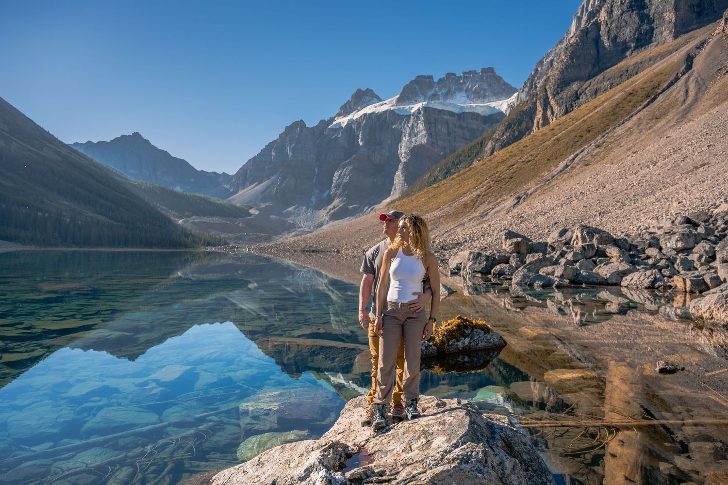A couple have professional photographs at sunrise at Consolation Lakes near Moraine Lake in Banff National Park.